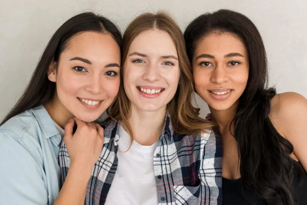 Three young women showcasing bright, healthy smiles after receiving a $100 discount from the Refer a Friend program at Limestone Hills Orthodontics in Austin, TX.