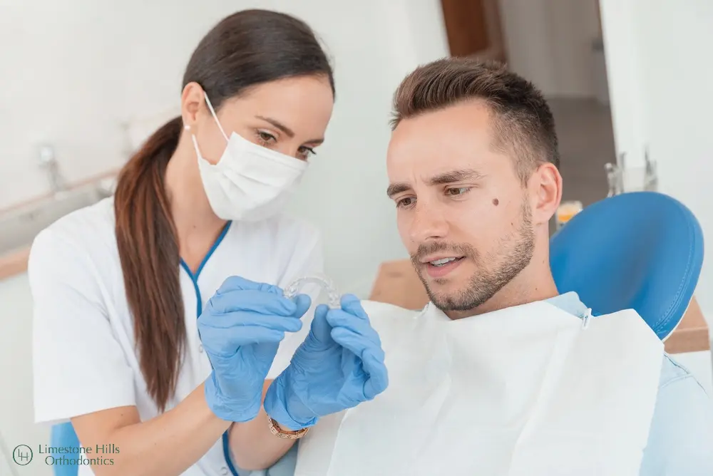 a woman holding an Invisalign. Lingual Braces vs Invisalign