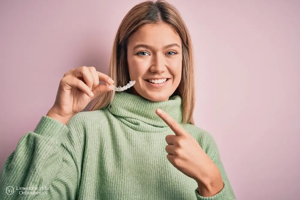 a woman pointing at her Byte vs Invisalign aligner