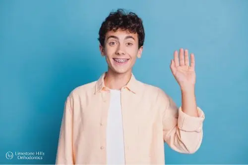 a boy waving at the camera illustrating Braces for Overbite