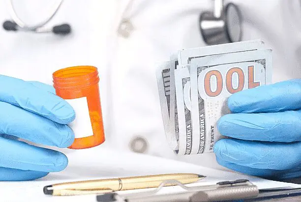 Gloved hands hold a prescription bottle and US dollar bills on a medical desk. Limestone Hills Orthodontics in Austin, TX, discusses treatment costs and payment.
