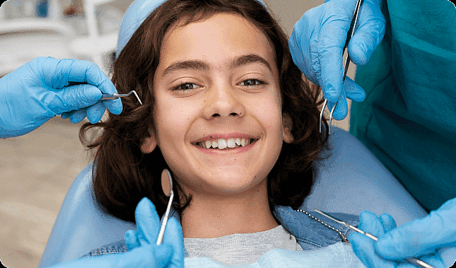 A smiling young person, who appears to be of Middle Eastern descent based on their features and complexion, is surrounded by dental tools. Limestone Hills Orthodontics in Austin, TX.