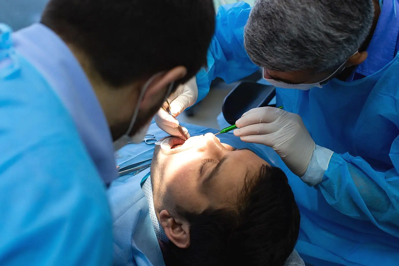 A dentist examines a patient's open mouth, potentially assessing the effects of tongue thrust. Limestone Hills Orthodontics in Austin, TX, can diagnose and address this issue.