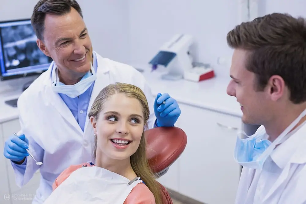Orthodontist and assistant discussing treatment options with a female patient after her Orthodontic Treatment for Sleep Apnea
