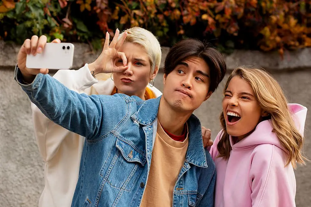 Three young adults, who appear to be of diverse ethnic backgrounds, take a selfie. Limestone Hills Orthodontics in Austin, TX, helps create picture-perfect smiles.