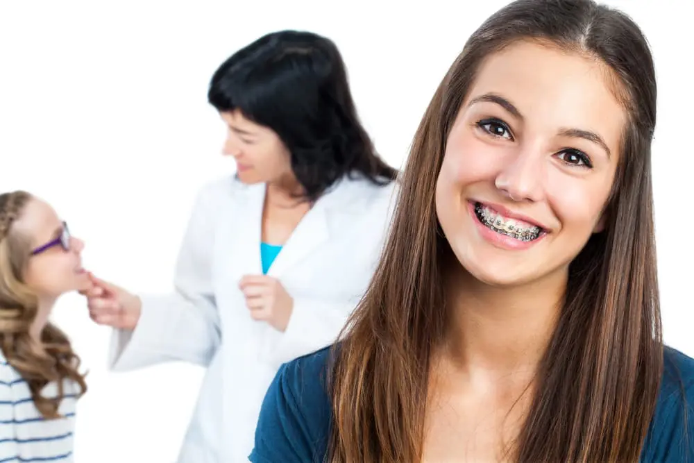 Smiling young adult learning about affordable braces cost solutions at a clinic
