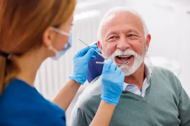 Dentist examining an older male patient during a consultation about Dietary Restrictions and Oral Hygiene During Recovery after Jaw Surgery at Limestone Hills Orthodontics in Austin, TX. Dentist examining an older male patient during a consultation about Dietary Restrictions and Oral Hygiene During Recovery after Jaw Surgery at Limestone Hills Orthodontics in Austin, TX.