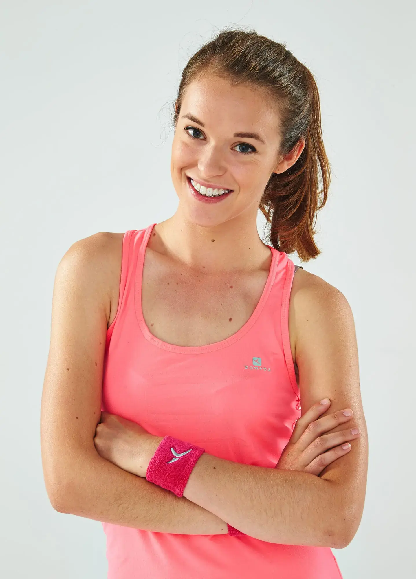 Smiling young woman with crossed arms wearing self-ligating clear ceramic braces at Limestone Hills Orthodontics in Austin, TX. Smiling young woman with crossed arms wearing self-ligating clear ceramic braces at Limestone Hills Orthodontics in Austin, TX.