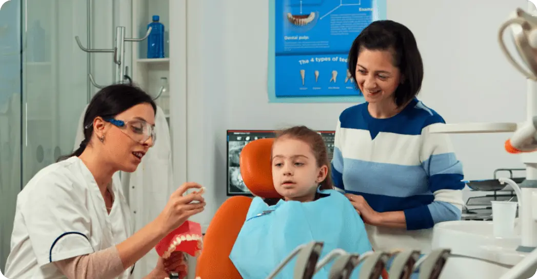 Dentist explains early orthodontic care to a young girl at Limestone Hills Orthodontics in Austin, TX. Dentist explains early orthodontic care to a young girl at Limestone Hills Orthodontics in Austin, TX.