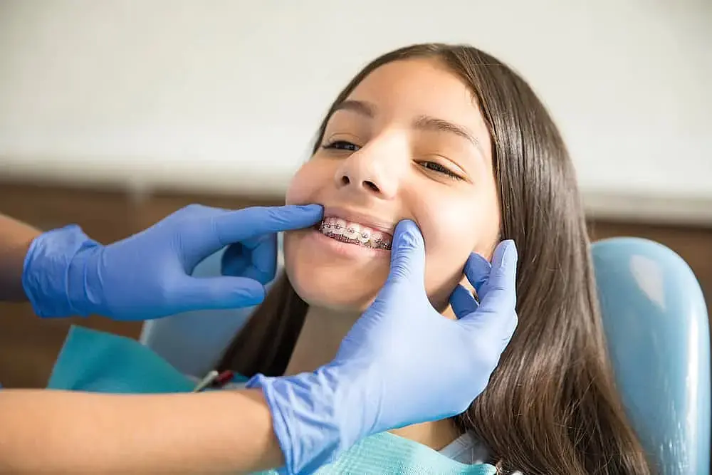 Young girl having her traditional braces checked at Limestone Hills Orthodontics in Austin, TX Young girl having her traditional braces checked at Limestone Hills Orthodontics in Austin, TX
