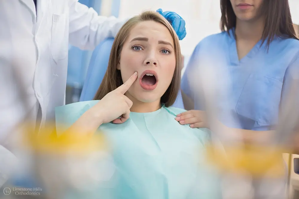 Young woman sitting in a dental chair with mouth open during an exam, highlighting How Orthodontics Supports Overall Health in Austin, TX