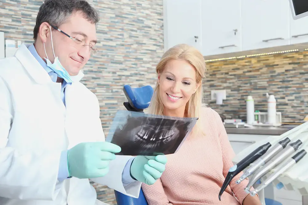 male dentist showing x rays - Why Dental Degrees Matter When Choosing an Orthodontist in Austin, TX.