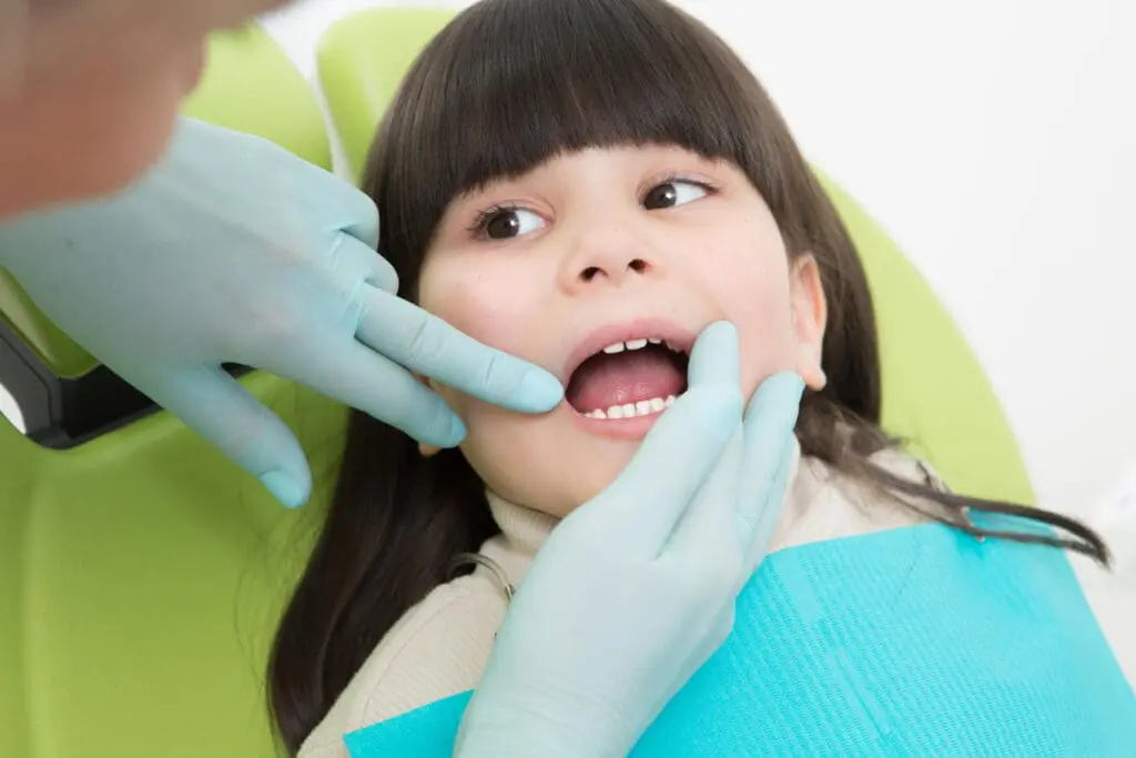 Kids Orthodontist at Limestone Hills Orthodontics in Austin, TX examining a young girl's teeth