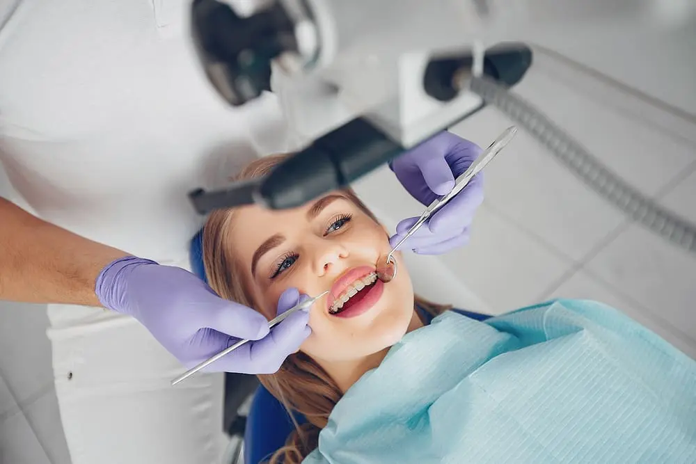 beautiful girl sitting in the dentist office - Best Age for Braces: An Age-by-Age Timeline 