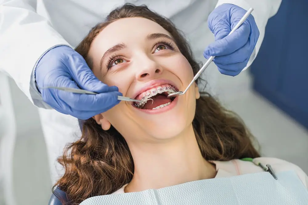 cropped view dentist latex gloves examining cheerful woman metal braces - Jaw Surgery vs Braces: When Is Orthognathic Surgery Needed? | Limestone Hills Orthodontics Austin TX
