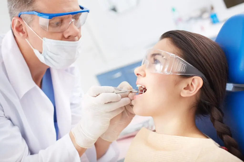 dentist examining patients teeth - Should You See a Dentist During Braces? What to Know | Limestone Hills Orthodontics Austin TX