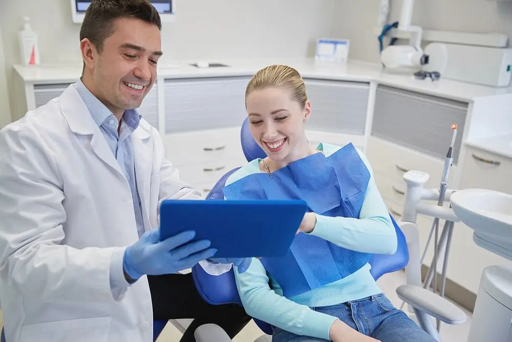 male dentist with tablet pc and woman patient - AI in Orthodontics: How Technology Is Changing Treatment | Limestone Hills Orthodontics Austin TX