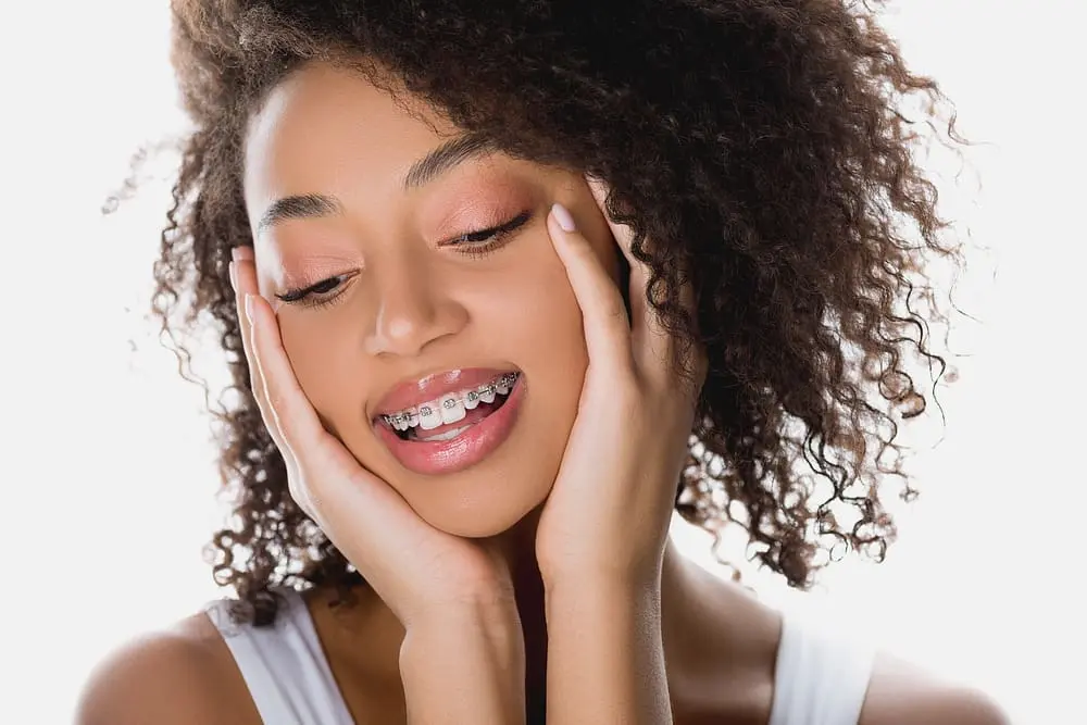 pretty happy african american girl metal braces isolated white - Professional Adults with Braces: A Workplace Confidence Guide | Limestone Hills Orthodontics Austin TX