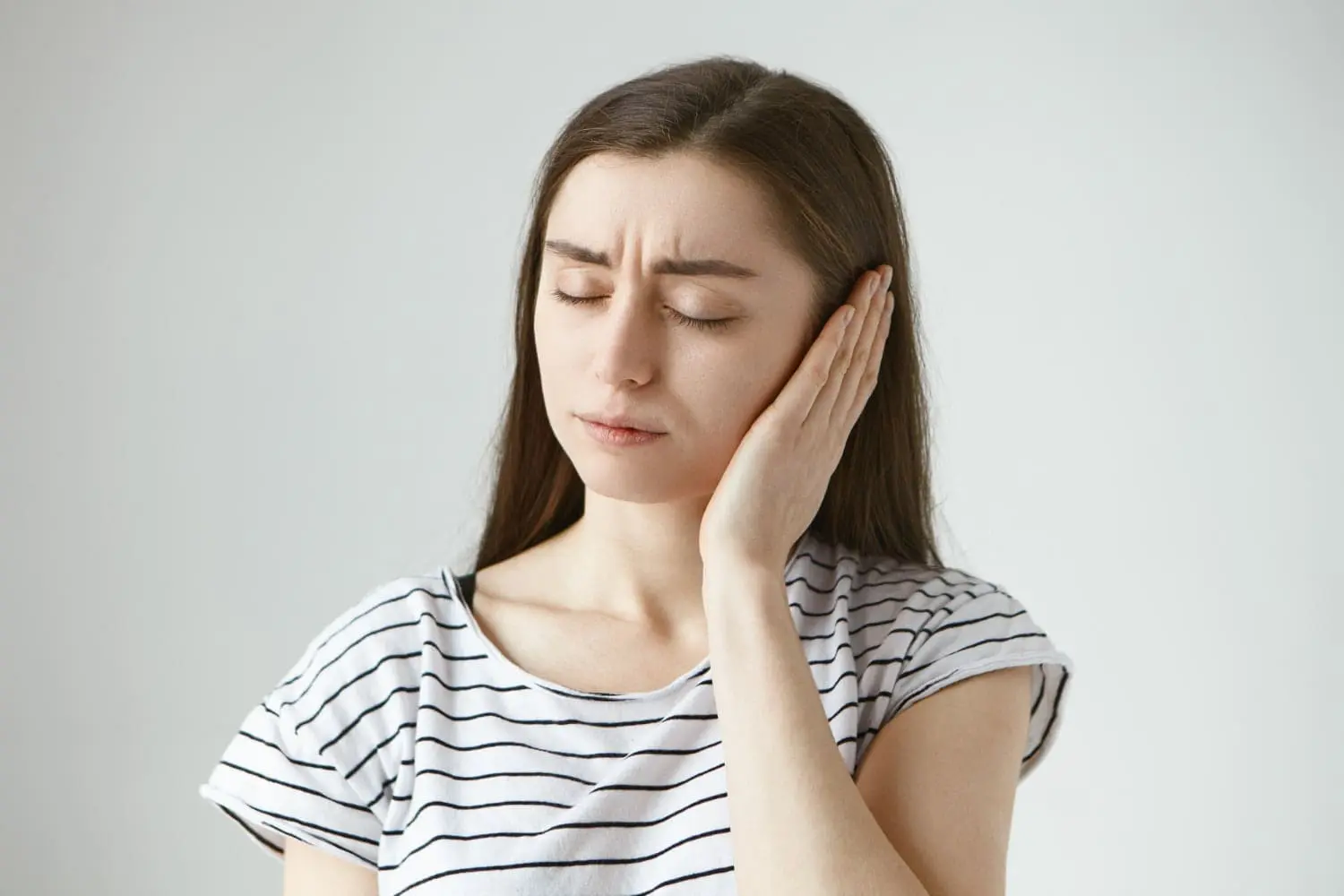 Woman experiencing jaw fatigue and temple headaches before receiving TMJ treatment at Limestone Hills Orthodontics in Austin, TX